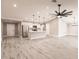 Bright open-concept living area with high ceilings, modern lighting fixtures, and light gray wood-look flooring at 16403 Perdida Ct, Punta Gorda, FL 33955