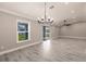 Spacious living room features gray wood floors, modern lighting, and sliding glass door at 16403 Perdida Ct, Punta Gorda, FL 33955