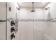Modern glass enclosed shower with light tile, gray accent and matte black fixtures at 16403 Perdida Ct, Punta Gorda, FL 33955