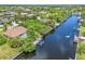 Wide canal view from the sky showcasing the home's private dock and lush landscaping at 17125 Canary Ln, Port Charlotte, FL 33948