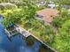 Aerial view of the backyard featuring a screened pool, dock, and canal access at 17125 Canary Ln, Port Charlotte, FL 33948