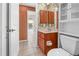 Lovely bathroom features a wood vanity, framed mirror, tiled flooring and an adjacent toilet and walk through door at 17125 Canary Ln, Port Charlotte, FL 33948
