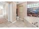 Bright bathroom featuring tile floors, a soaking tub with artistic wall and large window, and built in shelving at 17125 Canary Ln, Port Charlotte, FL 33948