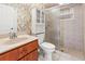 Inviting bathroom features a sink vanity, framed mirror, white shelving, and a tiled shower with a glass door at 17125 Canary Ln, Port Charlotte, FL 33948