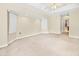 Bright bedroom boasts neutral carpeting, ceiling fan, and a view into the ensuite bathroom at 17125 Canary Ln, Port Charlotte, FL 33948
