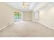 Spacious bedroom features neutral carpeting, ceiling fan, and sliding glass doors to the lanai and pool at 17125 Canary Ln, Port Charlotte, FL 33948