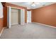 Cozy bedroom features plush carpet, ceiling fan, and closet with shelving perfect for comfort and storage at 17125 Canary Ln, Port Charlotte, FL 33948
