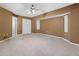 Large carpeted bedroom featuring a ceiling fan and a window for natural light and a spacious closet at 17125 Canary Ln, Port Charlotte, FL 33948