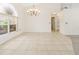 Open dining area with tile flooring, chandelier, and a large window that allows for natural light at 17125 Canary Ln, Port Charlotte, FL 33948