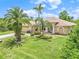 Charming one-story home with well-manicured lawn, mature palms, and a two car garage at 17125 Canary Ln, Port Charlotte, FL 33948