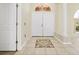 Bright foyer featuring tile flooring, double entry doors, a side door, and a decorative medallion at 17125 Canary Ln, Port Charlotte, FL 33948