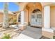 Welcoming front entrance with an arched doorway, decorative columns, secure gates, and manicured shrubbery at 17125 Canary Ln, Port Charlotte, FL 33948