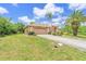 Charming single-story home with lush landscaping, mature palm trees, and a well-maintained lawn under a sunny, blue sky at 17125 Canary Ln, Port Charlotte, FL 33948