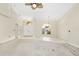 Bright, open living area with tile and carpet flooring, ceiling fan, and a view of the front entrance at 17125 Canary Ln, Port Charlotte, FL 33948