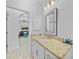Bathroom featuring granite countertops, framed mirror, and a view into living room at 1722 Amnesty Dr, North Port, FL 34288