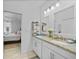 Bright bathroom with double sinks, granite countertops, and access to the bedroom at 1722 Amnesty Dr, North Port, FL 34288