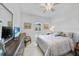 Well-lit bedroom boasts a shuttered window, ceiling fan, and comfortable bed with television at 1722 Amnesty Dr, North Port, FL 34288