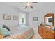 Bedroom featuring ceiling fan, woven dresser and colorful bedding and a window with curtains at 1722 Amnesty Dr, North Port, FL 34288