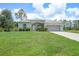 Charming home featuring a well-manicured lawn, colorful flower beds, and an attached two-car garage at 1722 Amnesty Dr, North Port, FL 34288