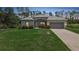 Inviting home with lush green lawn, manicured landscaping, and a driveway leading to an attached garage at 1722 Amnesty Dr, North Port, FL 34288