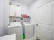 Laundry room featuring white appliances, cabinets, and a shelf for storage at 1722 Amnesty Dr, North Port, FL 34288