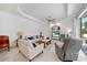 Spacious living room featuring a tray ceiling, tile floors, and a comfortable seating arrangement at 1722 Amnesty Dr, North Port, FL 34288