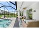 Screened-in patio with view of the pool, comfortable seating and serene backyard at 1722 Amnesty Dr, North Port, FL 34288