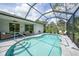 Screened-in pool with beautiful blue water, brick patio and multiple seating options for relaxing by the pool at 1722 Amnesty Dr, North Port, FL 34288