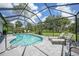 Backyard screened-in pool area with blue water, brick patio, chairs and lounge chairs for relaxation at 1722 Amnesty Dr, North Port, FL 34288