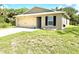 Single story home featuring a well-manicured lawn and a two-car garage at 17344 York Ave, Port Charlotte, FL 33948