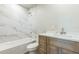 A neutral bathroom design is showcased with a shower and bath combination, a vanity, and white marble tiling at 175 Rodgers Ne Ave, Port Charlotte, FL 33952