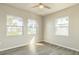 Bright bedroom with three windows, ceiling fan, and wood-look flooring at 175 Rodgers Ne Ave, Port Charlotte, FL 33952