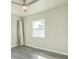 A clean bedroom showcasing a ceiling fan, window, and laminate floor at 175 Rodgers Ne Ave, Port Charlotte, FL 33952