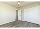 This bedroom features wood-look flooring, ceiling fan, walk in closet, and an open doorway to another room at 175 Rodgers Ne Ave, Port Charlotte, FL 33952