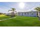 Charming single-story home featuring a lush green lawn and mature palm tree in a sunny neighborhood at 175 Rodgers Ne Ave, Port Charlotte, FL 33952