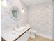 Charming bathroom with a floral wallpaper, updated vanity and fixtures, with modern lighting at 18610 Fort Smith Cir, Port Charlotte, FL 33948