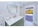 Charming bathroom with decorative wallpaper, green vanity and a direct view and access to the backyard at 18610 Fort Smith Cir, Port Charlotte, FL 33948