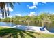 Private wooden dock on the canal with a relaxing chair, offering a serene waterfront experience at 18610 Fort Smith Cir, Port Charlotte, FL 33948