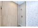 Walk-in shower featuring tiled walls, and a modern glass enclosure, adorned by wallpaper at 18610 Fort Smith Cir, Port Charlotte, FL 33948