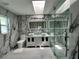 Modern bathroom featuring a double vanity, skylight, and a glass-enclosed shower at 21287 Birwood Ave, Port Charlotte, FL 33954