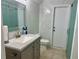 Modern bathroom with marble tiling, updated vanity, and glass-door shower at 21287 Birwood Ave, Port Charlotte, FL 33954