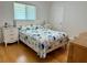 Comfortable bedroom featuring a queen bed, blue floral bedding, and hardwood floors at 21287 Birwood Ave, Port Charlotte, FL 33954