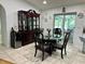 Bright dining room featuring a glass table set and dark wood china cabinet at 21287 Birwood Ave, Port Charlotte, FL 33954