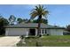 Charming single-story home featuring a well-maintained lawn and a stately palm tree at 21287 Birwood Ave, Port Charlotte, FL 33954