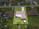 Aerial view of property showcasing the home's layout, well-manicured lawn, sheds, and neighborhood surroundings at 21460 Sheldon Ave, Port Charlotte, FL 33952