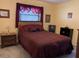 Cozy bedroom with carpet, complemented by a bed featuring a decorative headboard and matching curtains at 21460 Sheldon Ave, Port Charlotte, FL 33952