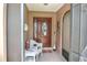 Welcoming foyer with decorative front door, interior screen door, tiled floor, and a charming seating area at 21460 Sheldon Ave, Port Charlotte, FL 33952