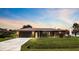 Charming single-story home featuring a well-manicured lawn, brown metal roof, and inviting curb appeal at 21460 Sheldon Ave, Port Charlotte, FL 33952