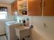 Functional laundry room with a washing machine, utility sink, and ample storage space at 21460 Sheldon Ave, Port Charlotte, FL 33952