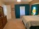 Carpeted main bedroom featuring ensuite bath access, closet, and bright bay windows at 21460 Sheldon Ave, Port Charlotte, FL 33952